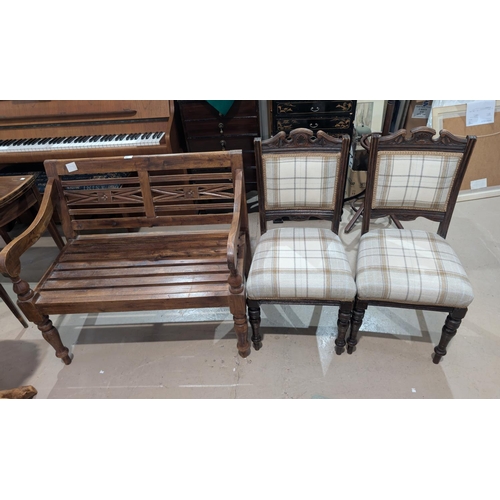 851 - A small 2 seater stained wood garden bench; a pair of Edwardian dining chairs in fawn check.