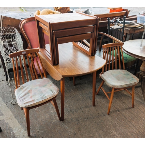 864 - A mid 20th Century teak drop leaf dining table and chairs.