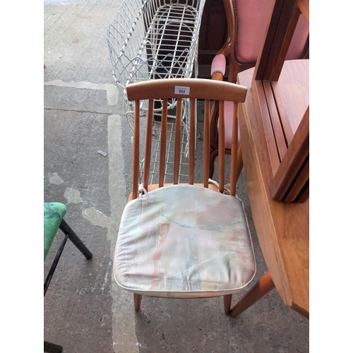 864 - A mid 20th Century teak drop leaf dining table and chairs.