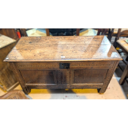 944 - An 18th century oak coffer chest with carved panels to the front.