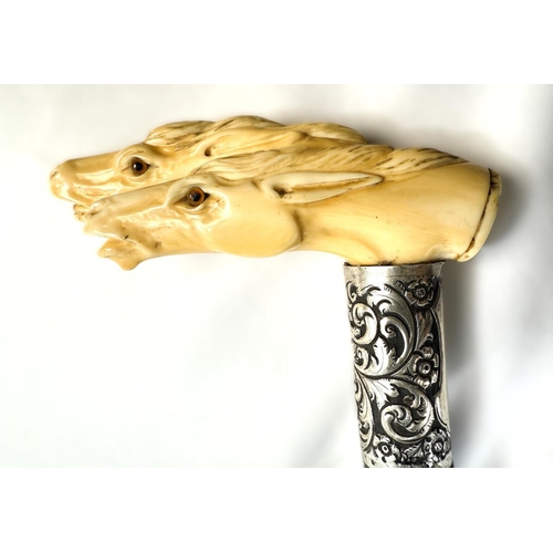 11 - A 19th Century ebonised walking stick with carved ivory handle of two horses' heads, 92cms.