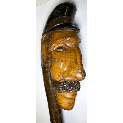 111 - An early 20th Century continental stick with carved head finial, 109cm, and another with ape finial,... 