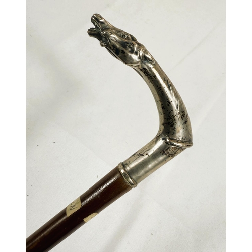 232 - A French 19th Century lady's riding stick with double horse head silver handle, 83cm.