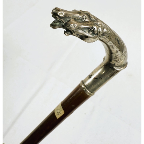 232 - A French 19th Century lady's riding stick with double horse head silver handle, 83cm.