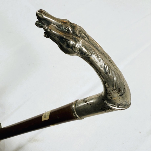 232 - A French 19th Century lady's riding stick with double horse head silver handle, 83cm.