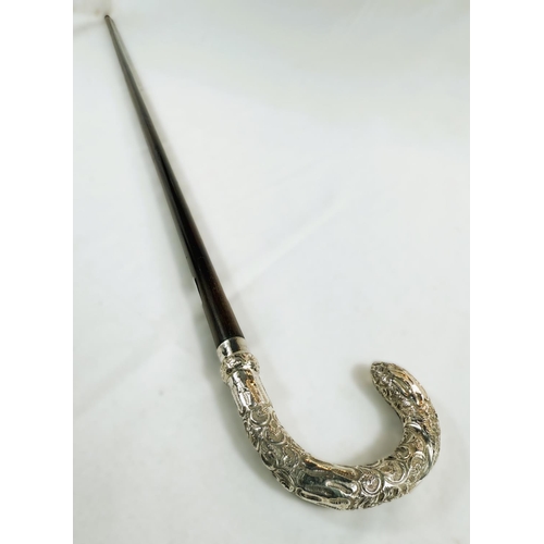 247 - An Edwardian period lady's stick with embossed silver mounted loop handle, London, 1907, 89cm.