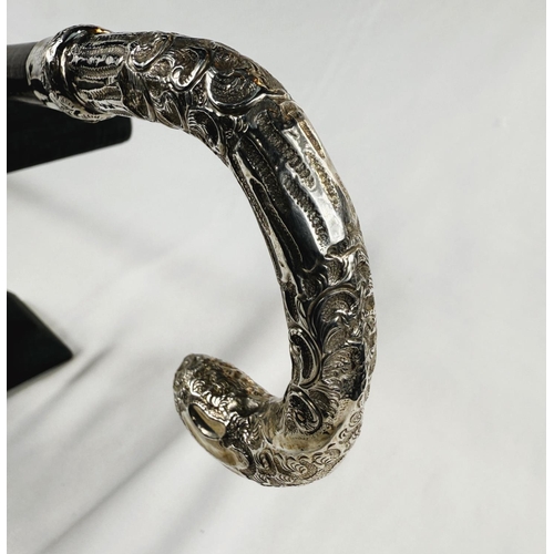 247 - An Edwardian period lady's stick with embossed silver mounted loop handle, London, 1907, 89cm.