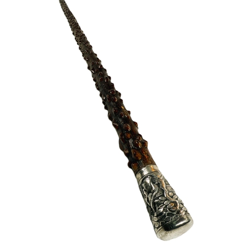 249 - A Chinese walking stick, the shaft with knobbly bark finish and having silver finial decorated in re... 