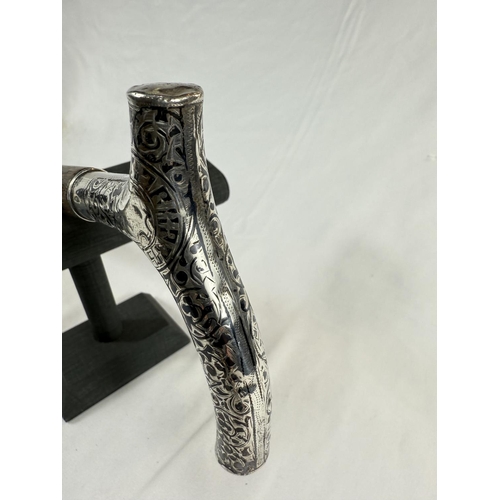 251 - A late 19th Century Russian ebonised walking stick with 84 standard silver handle decorated in niell... 