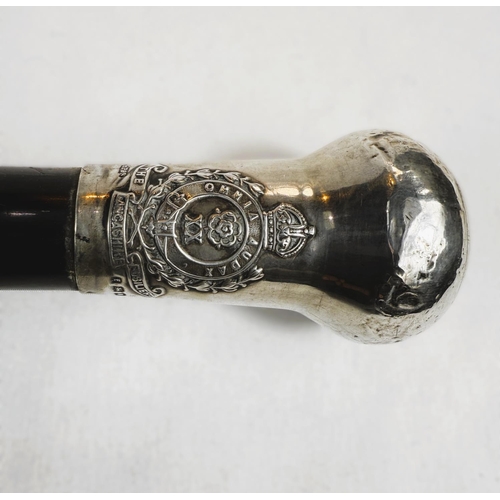 256 - An early 20th Century presentation stick with ebony shaft, the silver knop bearing the badge of the ... 