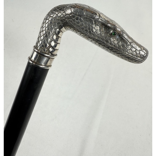 264 - A 19th Century continental ebonised walking stick with 800 standard silver snake's head handle inset... 