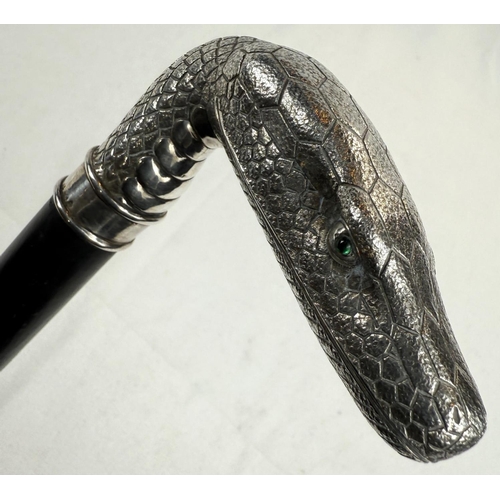 264 - A 19th Century continental ebonised walking stick with 800 standard silver snake's head handle inset... 