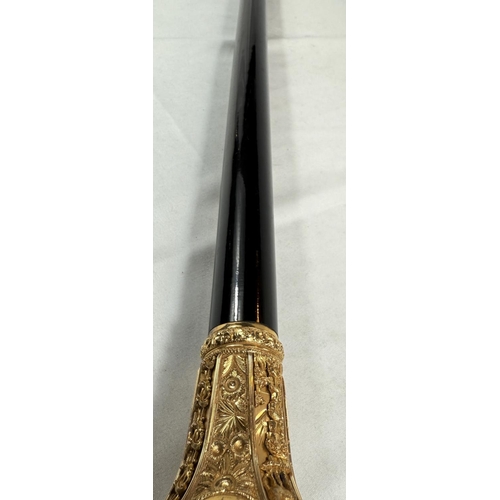 271 - A late Victorian presentation stick with tapering ebonised shaft, the gilt metal handle ornately dec... 