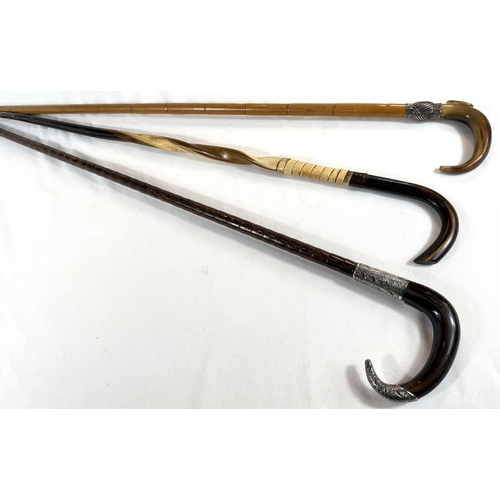 31 - Two vintage horn-handled sticks with white metal mounts, 91cms, and a twisted horn stick (3).