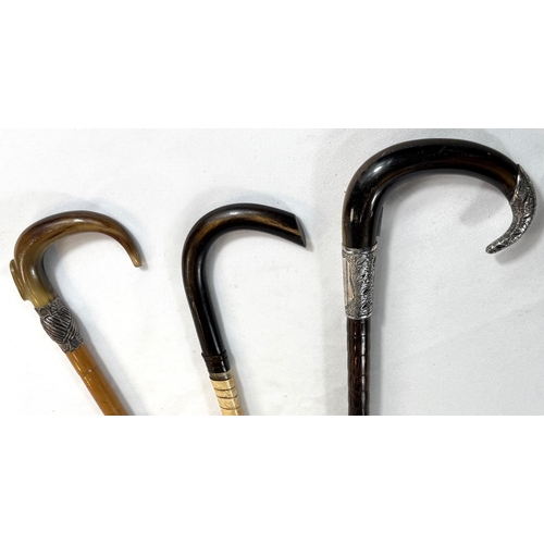 31 - Two vintage horn-handled sticks with white metal mounts, 91cms, and a twisted horn stick (3).