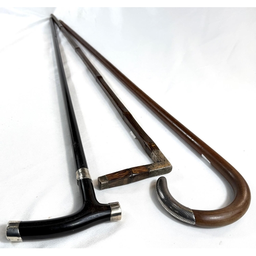 32 - A vintage square-section stick with white metal mount, another with niello work finial and an ebony ... 