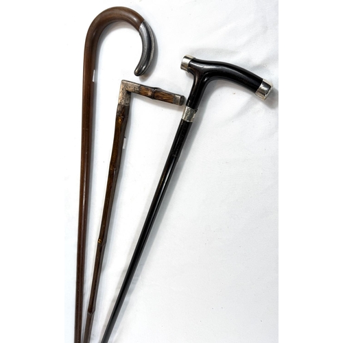 32 - A vintage square-section stick with white metal mount, another with niello work finial and an ebony ... 