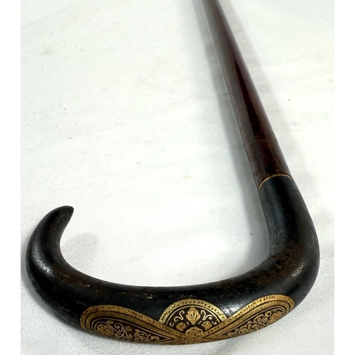 38 - An Edwardian slender hardwood stick with gilt inlaid steel handle, possibly Russian, 90cm.