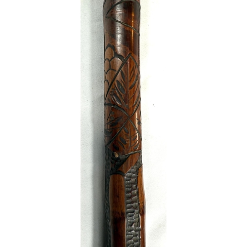 39 - A 19th Century Japanese bamboo walking cane with carved decoration of faunae, 89cm, and another with... 