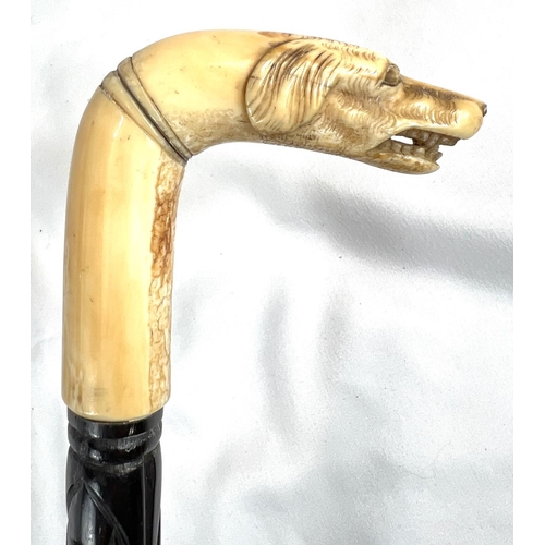 4 - A 19th Century ebony stick with carved ivory finial of a fierce dog, 89cms, and two other 19th Centu... 