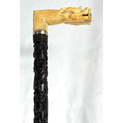 5 - A 19th Century ebonised stick with Japanese carved ivory handle and engraved silver band, 86cms, ano... 