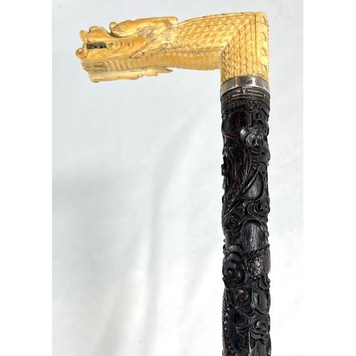 5 - A 19th Century ebonised stick with Japanese carved ivory handle and engraved silver band, 86cms, ano... 