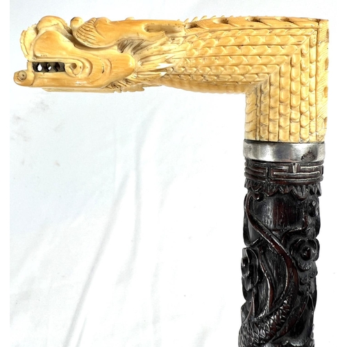 5 - A 19th Century ebonised stick with Japanese carved ivory handle and engraved silver band, 86cms, ano... 