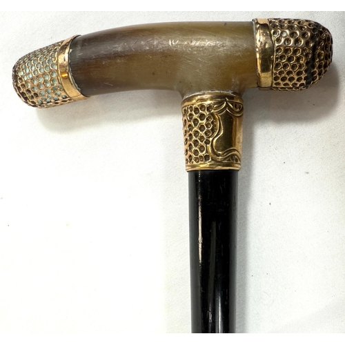 59 - A 19th Century horn-handled stick with gilt metal mounts and ebony shaft, 88cm, and a similar stick ... 