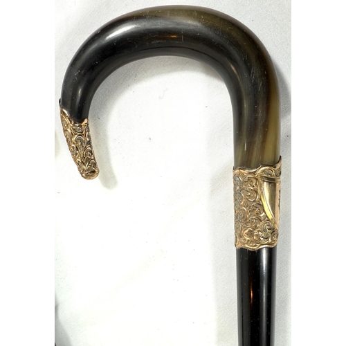 59 - A 19th Century horn-handled stick with gilt metal mounts and ebony shaft, 88cm, and a similar stick ... 