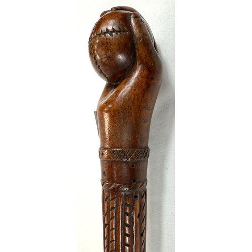 65 - A vintage carved hardwood stick of Asian origin, the finial with hand clasping a cricket ball, 91cm,... 