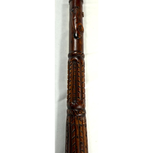 65 - A vintage carved hardwood stick of Asian origin, the finial with hand clasping a cricket ball, 91cm,... 