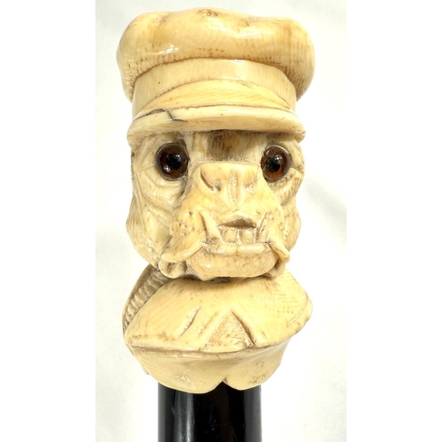 9 - A 19th Century walking stick with carved ivory finial of a bulldog in a driver's cap, 89cms.Submissi... 