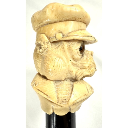 9 - A 19th Century walking stick with carved ivory finial of a bulldog in a driver's cap, 89cms.Submissi... 