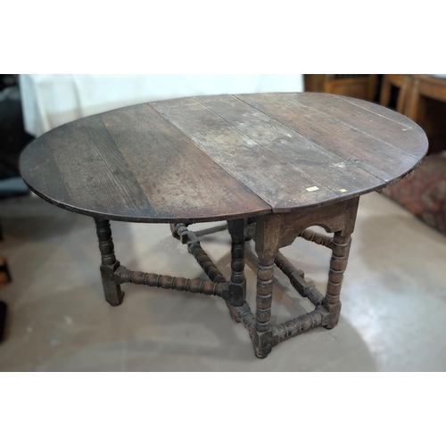 1019 - An 18th century oval oak drop leaf occasional table on turned legs.