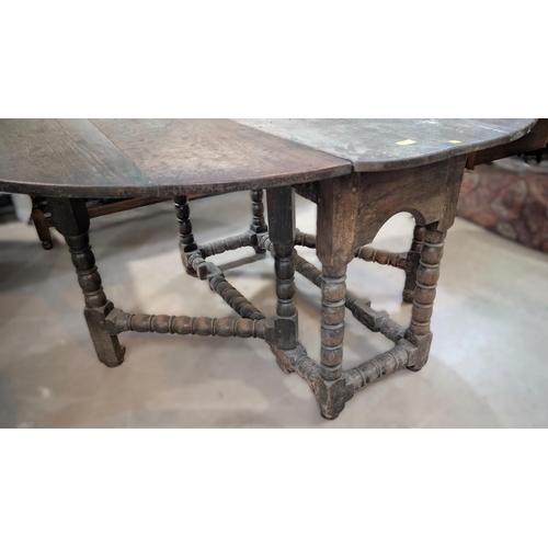 1019 - An 18th century oval oak drop leaf occasional table on turned legs.