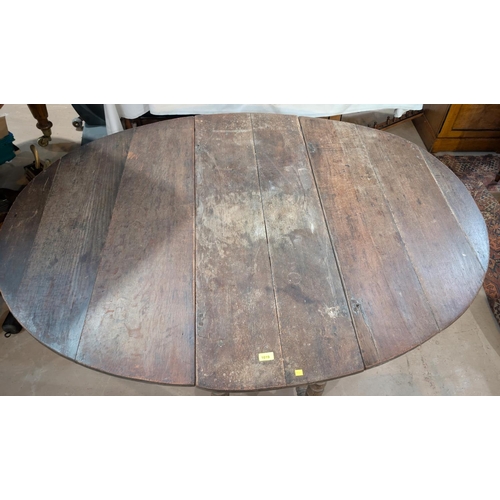 1019 - An 18th century oval oak drop leaf occasional table on turned legs.