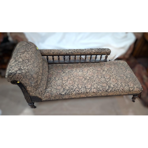 1020 - An ebonised framed spindle back chaise longue in floral tapestry upholstery.