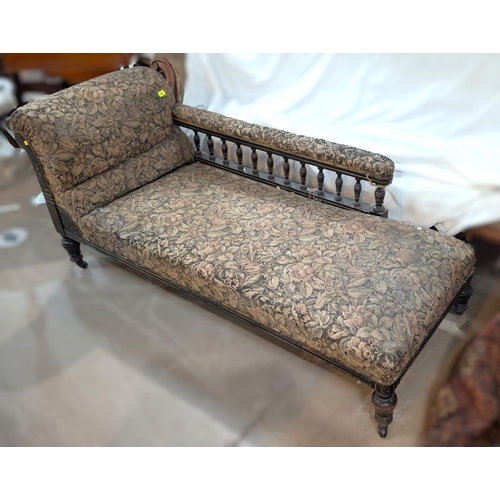 1020 - An ebonised framed spindle back chaise longue in floral tapestry upholstery.