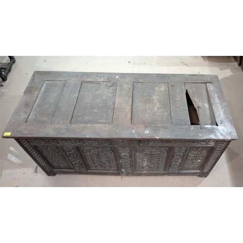 1023 - An 18th century oak framed and panelled blanket box with extensive carved decoration enclosed by 2 d... 