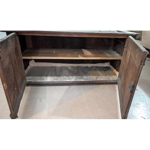 1023 - An 18th century oak framed and panelled blanket box with extensive carved decoration enclosed by 2 d... 