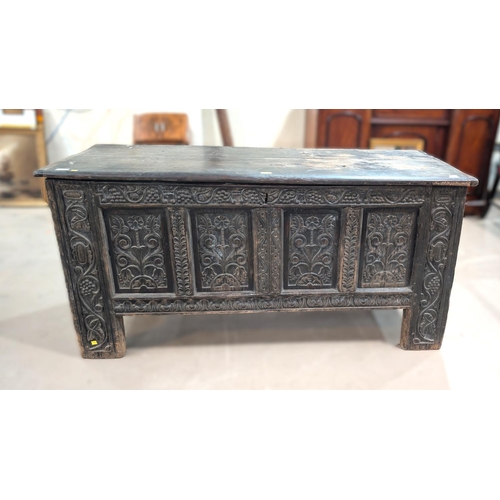 1024 - A large 18th century oak carved two panel top blanket box with four carved panels, scrolling grape a... 