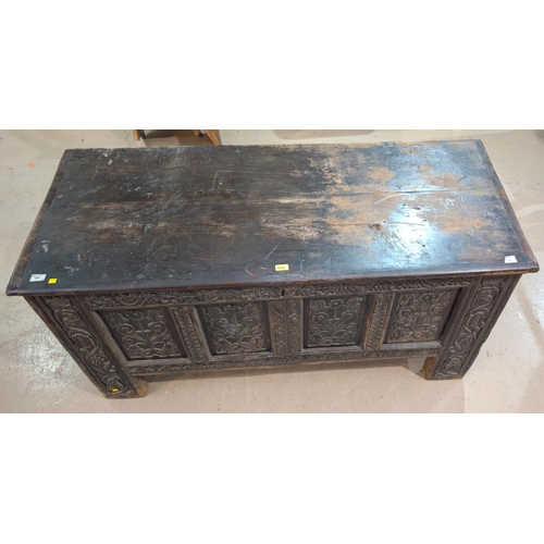 1024 - A large 18th century oak carved two panel top blanket box with four carved panels, scrolling grape a... 