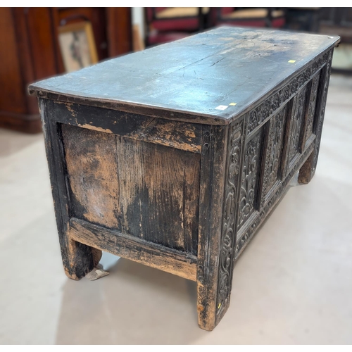 1024 - A large 18th century oak carved two panel top blanket box with four carved panels, scrolling grape a... 