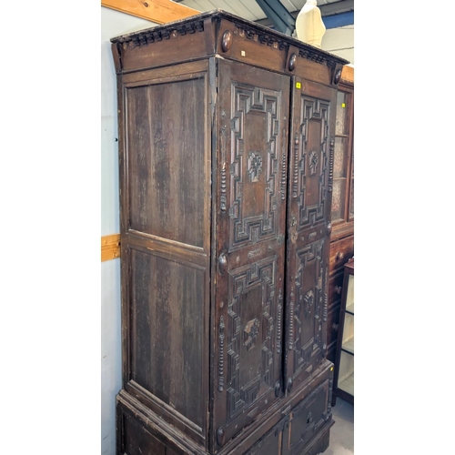 1032 - A 19th century William and Mary style oak side cabinet with extensive geometric moulding enclosed by... 