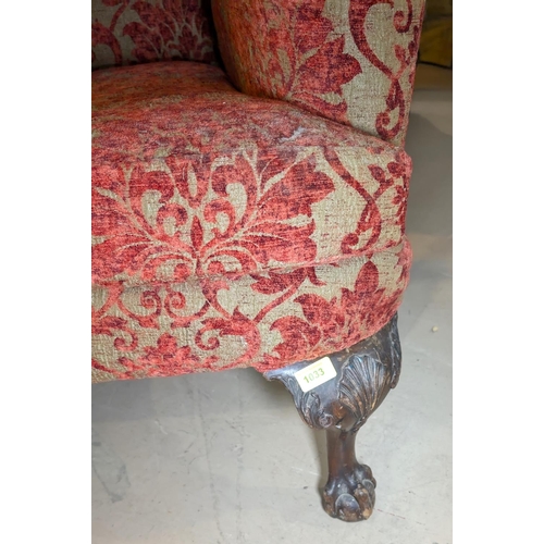 1033 - A 19th century Georgian style wing back armchair on shell carved cabriole legs and ball and claw fee... 