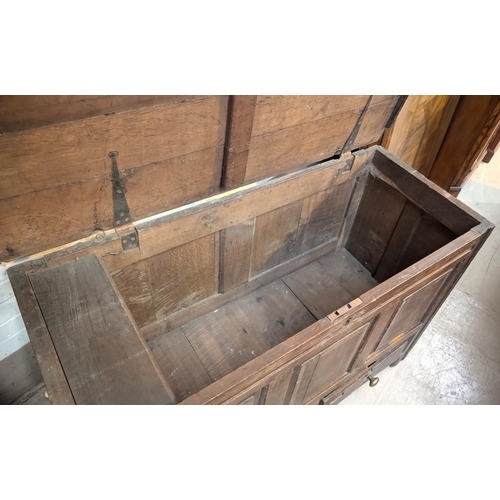 1038 - An 18th century oak mule chest with hinged lid and tripe fielded panels to the front, 2 drawers belo... 