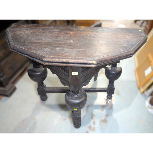 1043 - An 18th century canted oak fold over occasional table on heavy turned bulbous legs and cross stretch... 