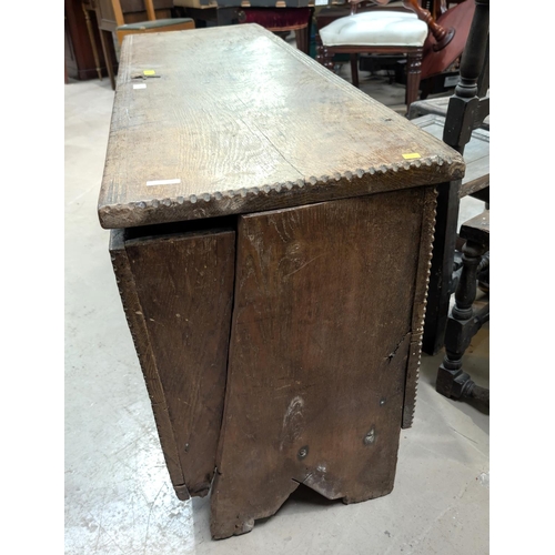 1047 - An early 18th century 4 plank oak chest with hinged lid, width 138cm (front legs cut down)