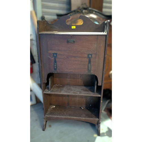 1053 - An Arts & Crafts style oak fall front secretaire with strap handles and 2 open shelves under, he... 