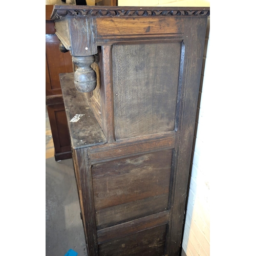 1057 - An 18th century oak court cupboard with twin diamond carved upper doors and framed and panelled sing... 